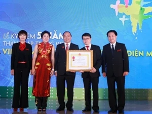 越南政府副总理阮春福受国家主席委托向越通社Vietnam Plus电子报全体干部授予三级劳动勋章